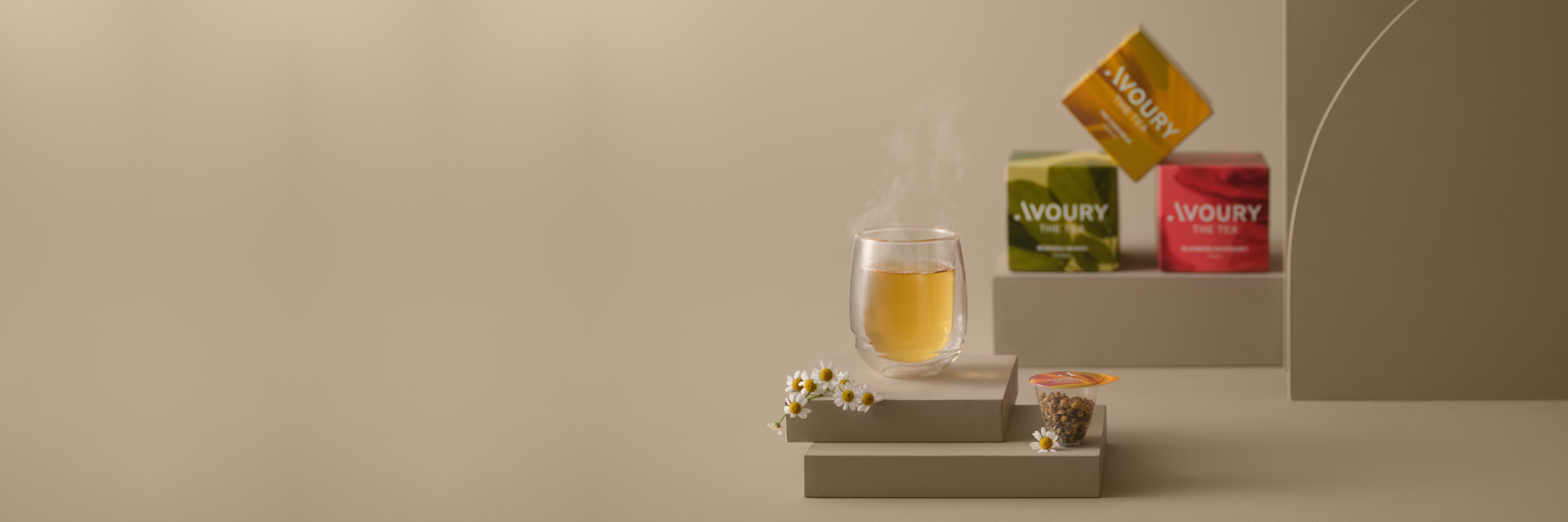 Tea glass with tea boxes in the background.